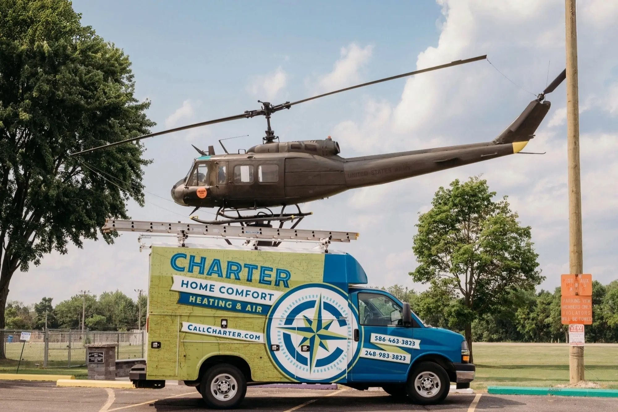Charter Home Comfort Heating & Air service van with a Bell UH-1 Iroquois helicopter in Fraser, Mi  